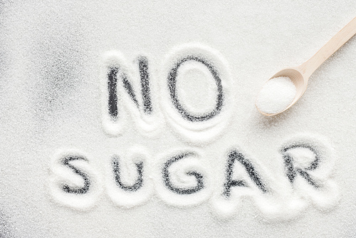 no sugar lettering written on granulated sugar with wooden spoon