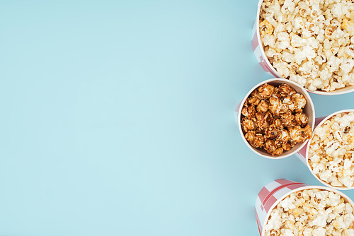 top view of buckets with popcorn in vertical row isolated on blue