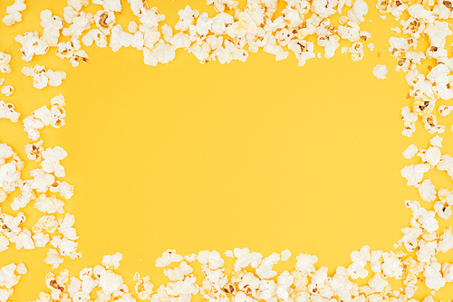 frame made of fresh tasty popcorn isolated on yellow