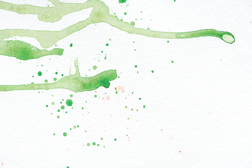 abstract green watercolor stains and splatters on white paper