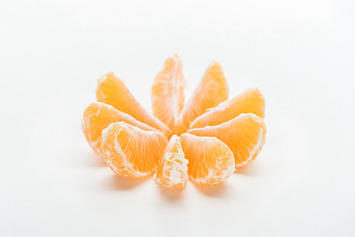 ripe orange tangerine slices arranged in circle on white background