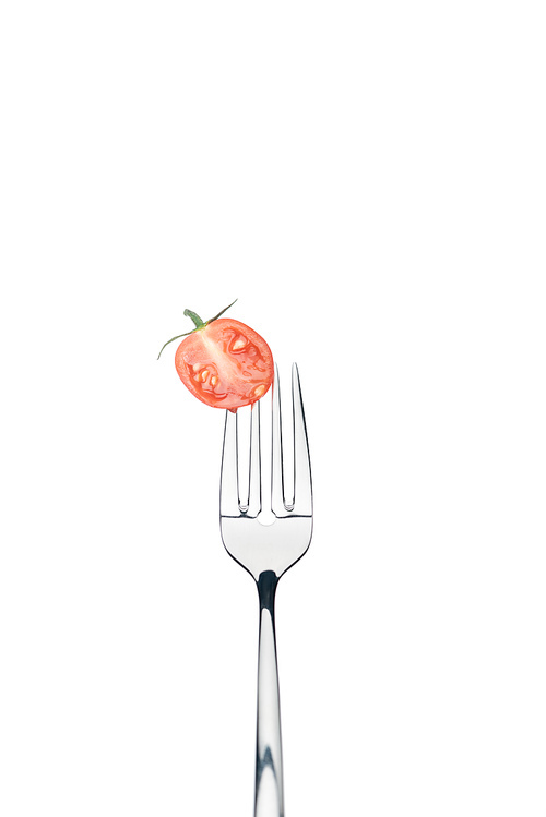 half of fresh red cherry tomato on fork isolated on white