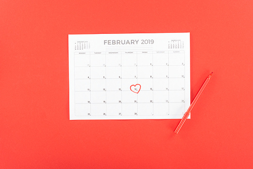 top view of calendar with 14th february date marked with heart isolated on red, st valentines day concept