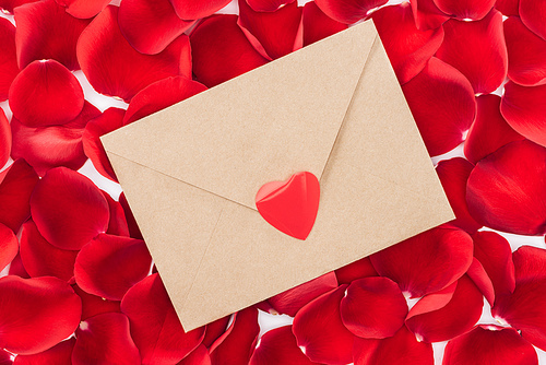 top view of envelope with heart and red rose petals on background, st valentines day concept