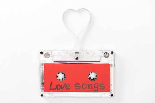 top view of audio cassette with 'love songs' lettering and heart symbol isolated on white, st valentines day concept