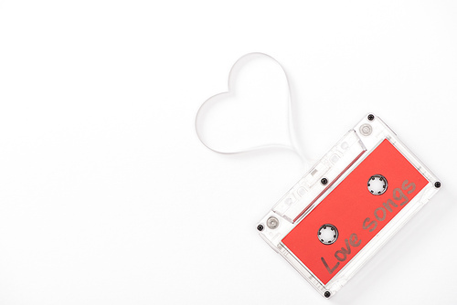 top view of audio cassette with 'love songs' lettering and heart symbol isolated on white with copy space, st valentines day concept