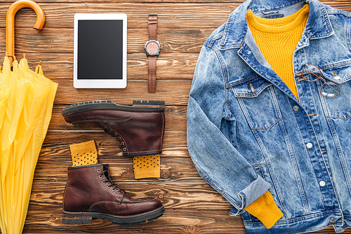 Flat lay with digital tablet, shoes and denim jacket on wooden background
