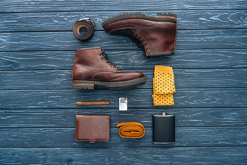 Flat lay with shoes, cigar and hip flask on wooden background