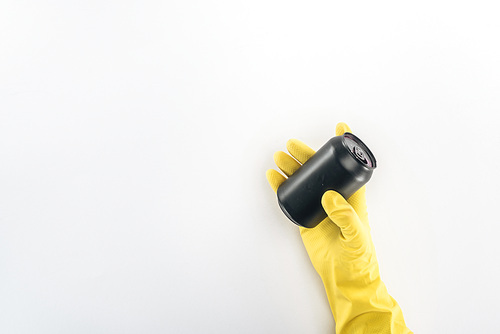 Cropped view of man in yellow rubber gloves holding empty black can on grey background