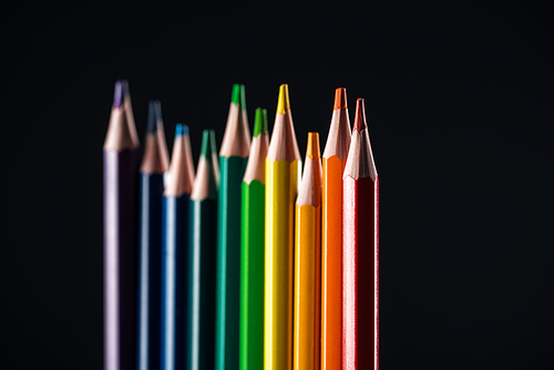 selective focus of sharpened multicolor pencils isolated on black, lgbt concept