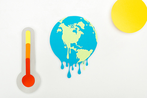 paper cut sun and melting earth, and thermometer with high temperature indication on scale on grey background, global warming concept