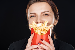 woman covering face with french fries isolated on black