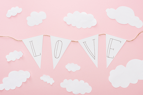 top view of paper garland with 'love' lettering isolated on pink, st valentines day concept