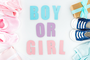top view of booties and sneakers, boy or girl lettering, gift boxes and bonnets