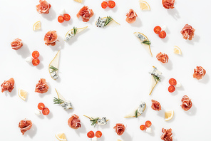 flat lay of sliced pears with blue cheese and rosemary twigs near prosciutto, and healthy ingredients on white background