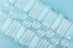 top view of arranged plastic watter bottles on turquoise background