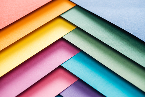 blue, orange, green, burgundy, yellow, pink and purple sheets of paper with copy space