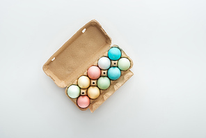 top view of pastel easter eggs in paper container isolated on grey