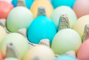 close up of pastel easter eggs in paper containers, selective focus