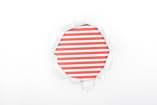 ragged hole in textured white paper on red striped background