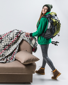 beautiful femele hiker with backpack at sofa with plaid