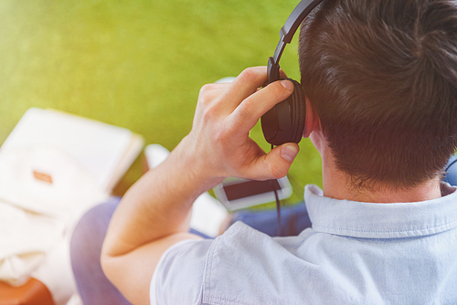 close-up shot of man in headphones sitting on grass