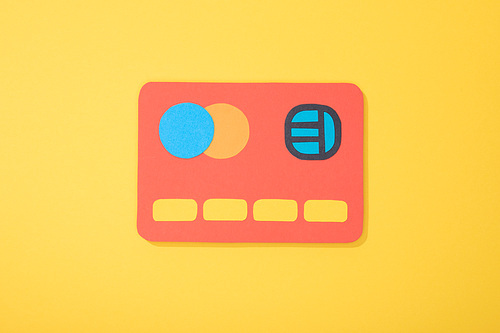 top view of red paper icon of credit card isolated on yellow