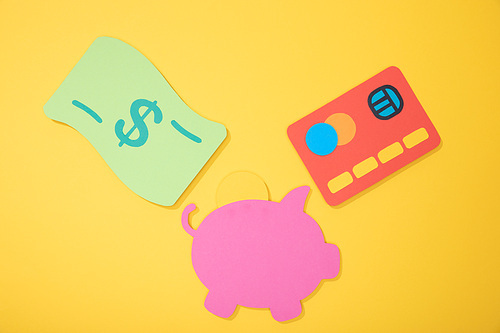top view of colorful paper icons isolated on yellow, finance concept