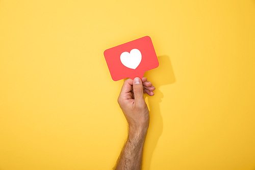 cropped view of man holding paper icon with white heart