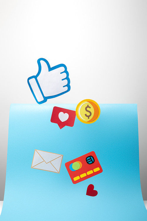 paper icons with envelope, coin, credit card, hearts and thumb up on blue and grey background