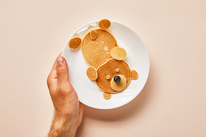 cropped view of pancakes on plate with one blueberry on pink, bear concept