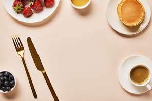 top view of served breakfast with berries, coffee, pancakes and empty space in middle
