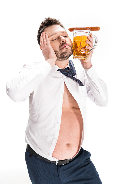 overweight man holding glass of beer with sausage and posing with eyes closed isolated on white