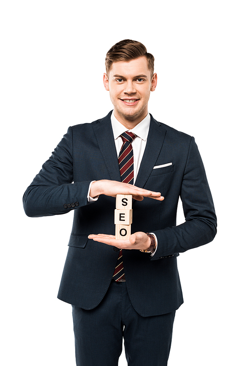 happy businessman holding wooden cubes with seo lettering isolated on white