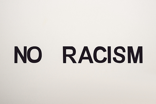 top view of black no racism lettering isolated on white