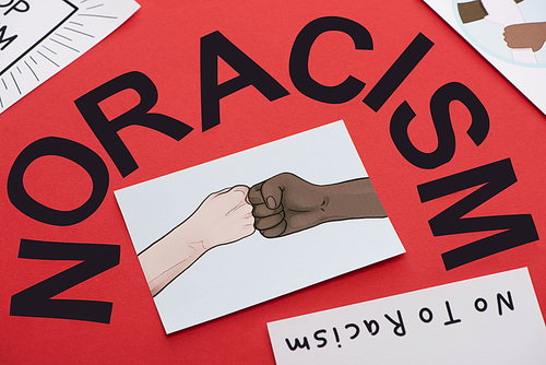 black no racism lettering and picture with drawn multiethnic hands doing fist bump on red background