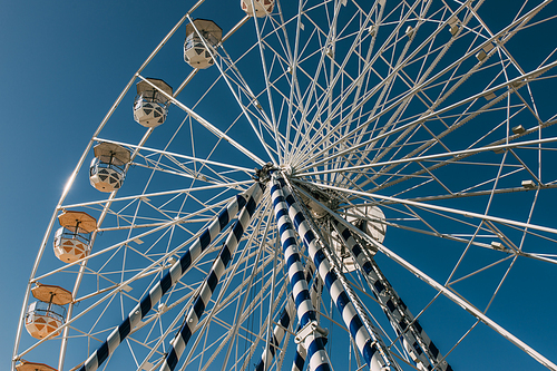 low angle view of ferris wheel against blue sky in summertime