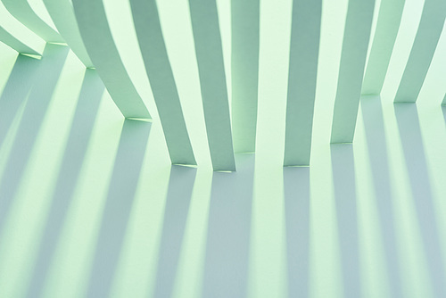 close up view of paper stripes with shadow on green background