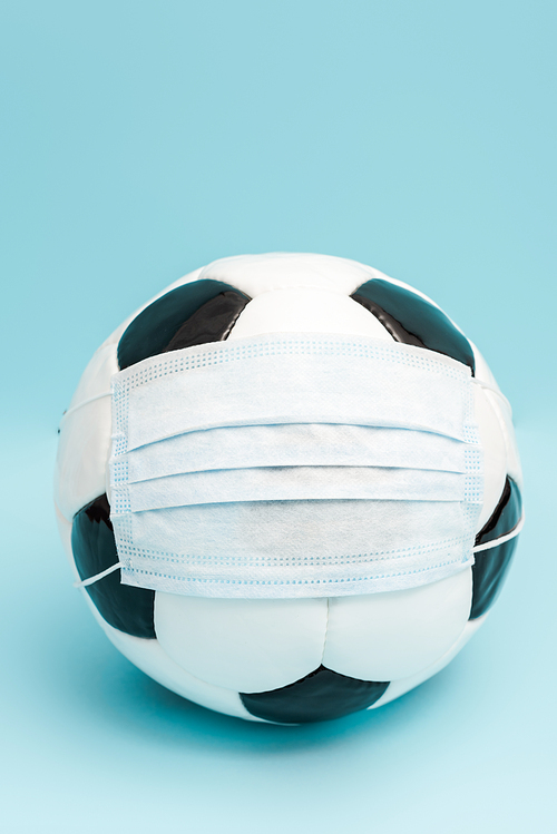 soccer ball in medical mask on blue