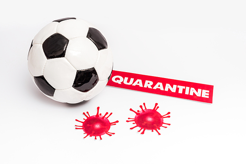 soccer ball near paper with quarantine lettering and drawn virus on white