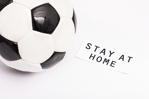 football near paper with stay at home lettering on white