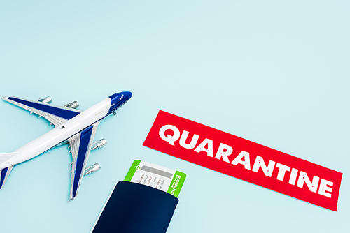 toy plane near paper with quarantine, passport and air ticket isolated on blue