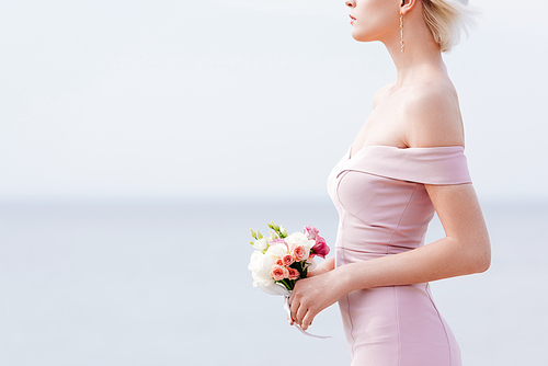 cropped view of slim elegant woman holding wedding bouquet