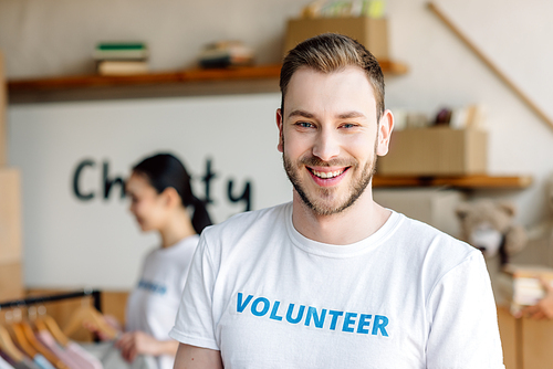 selective focus of handsome young man in white t-shirt with volunteer inscription