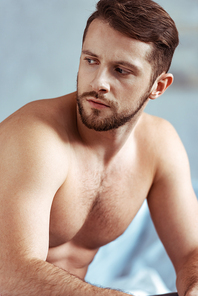 good-looking, sexy, shirtless and muscular man looking away in bedroom