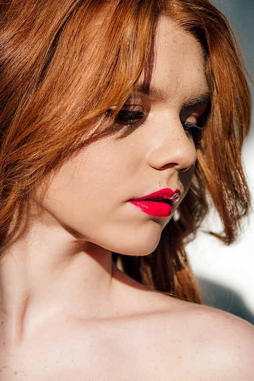 beautiful young redhead woman with red lips looking away