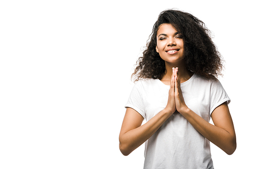 happy african american woman with praying hands and closed eyes isolated on white