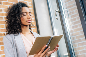 beautiful african american Casual businesswoman holding notebook in loft office