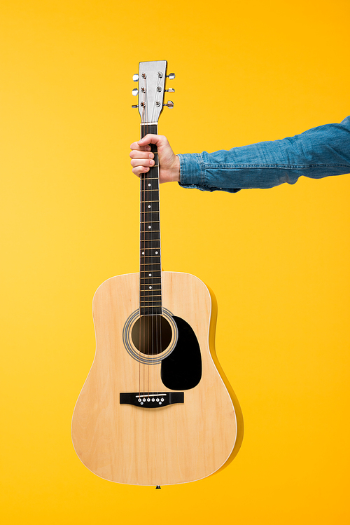 cropped view of man holding acoustic guitar Isolated On yellow