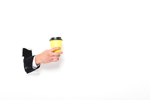 partial view of man holding coffee to go from hole in wall on white with copy space